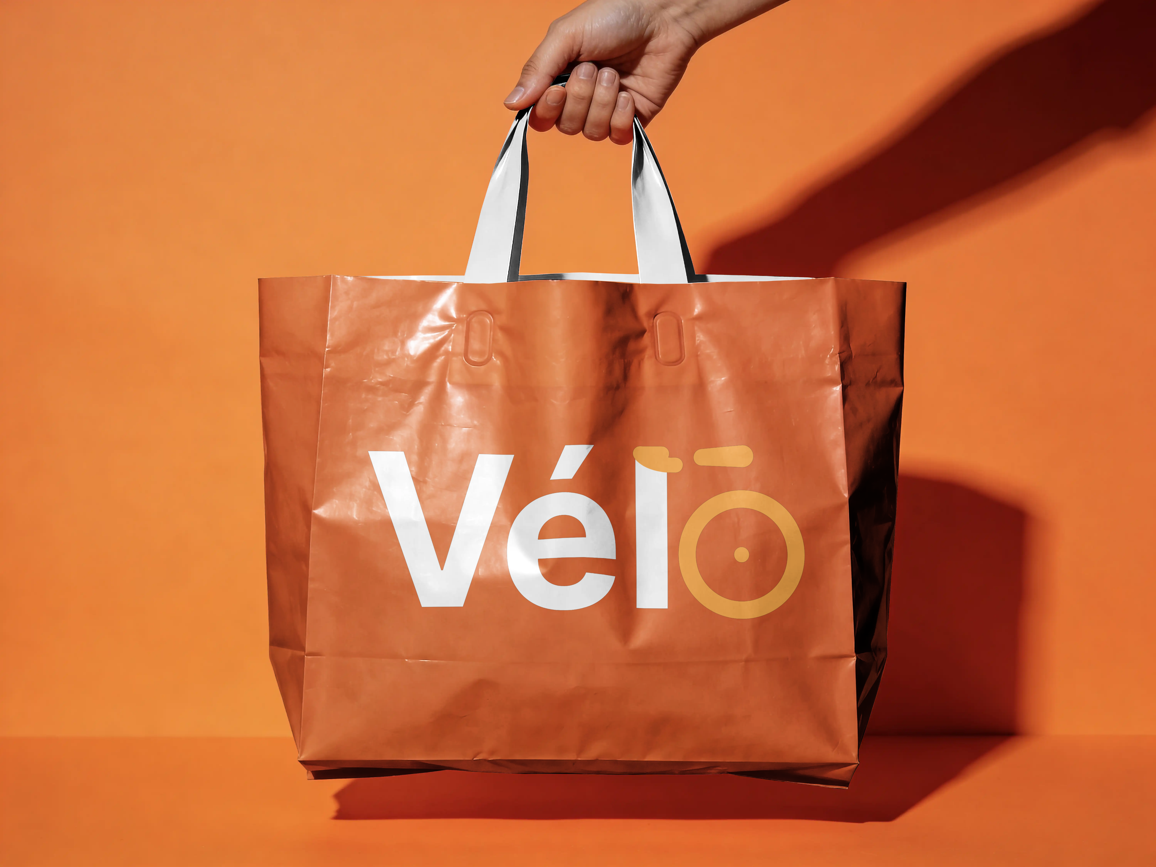 A hand holding a Vélo courier delivery bag
