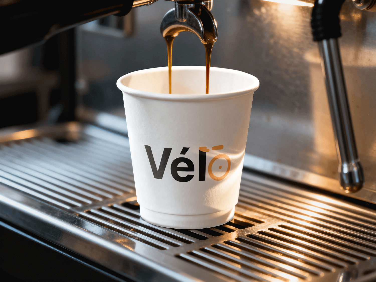 Vélo-branded hot drink cup under an espresso machine