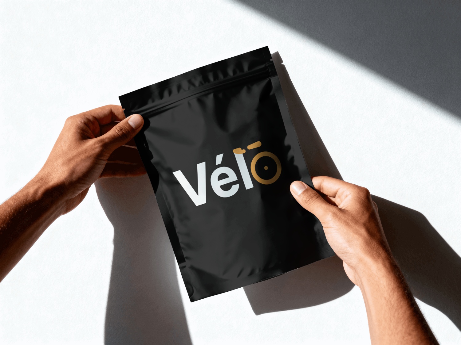Vélo-branded packaging pouch held in two hands